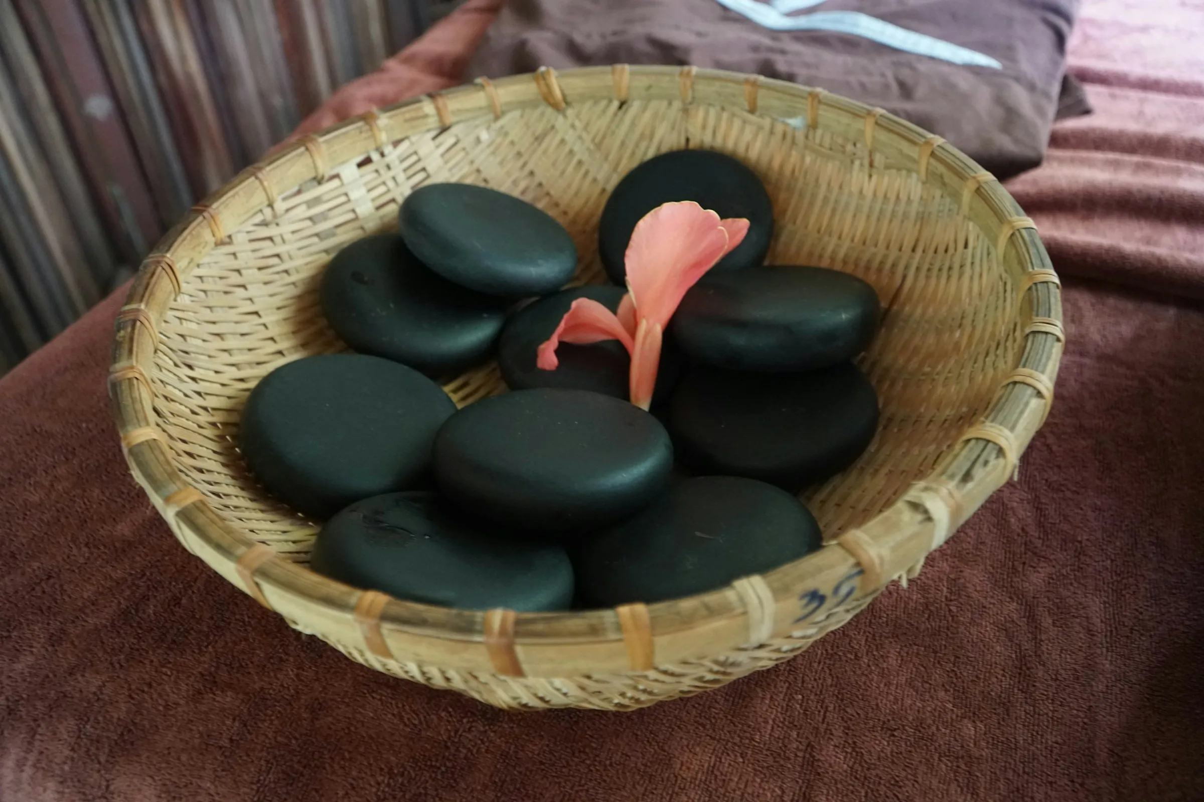 Cesto com pedras quentes para massagem