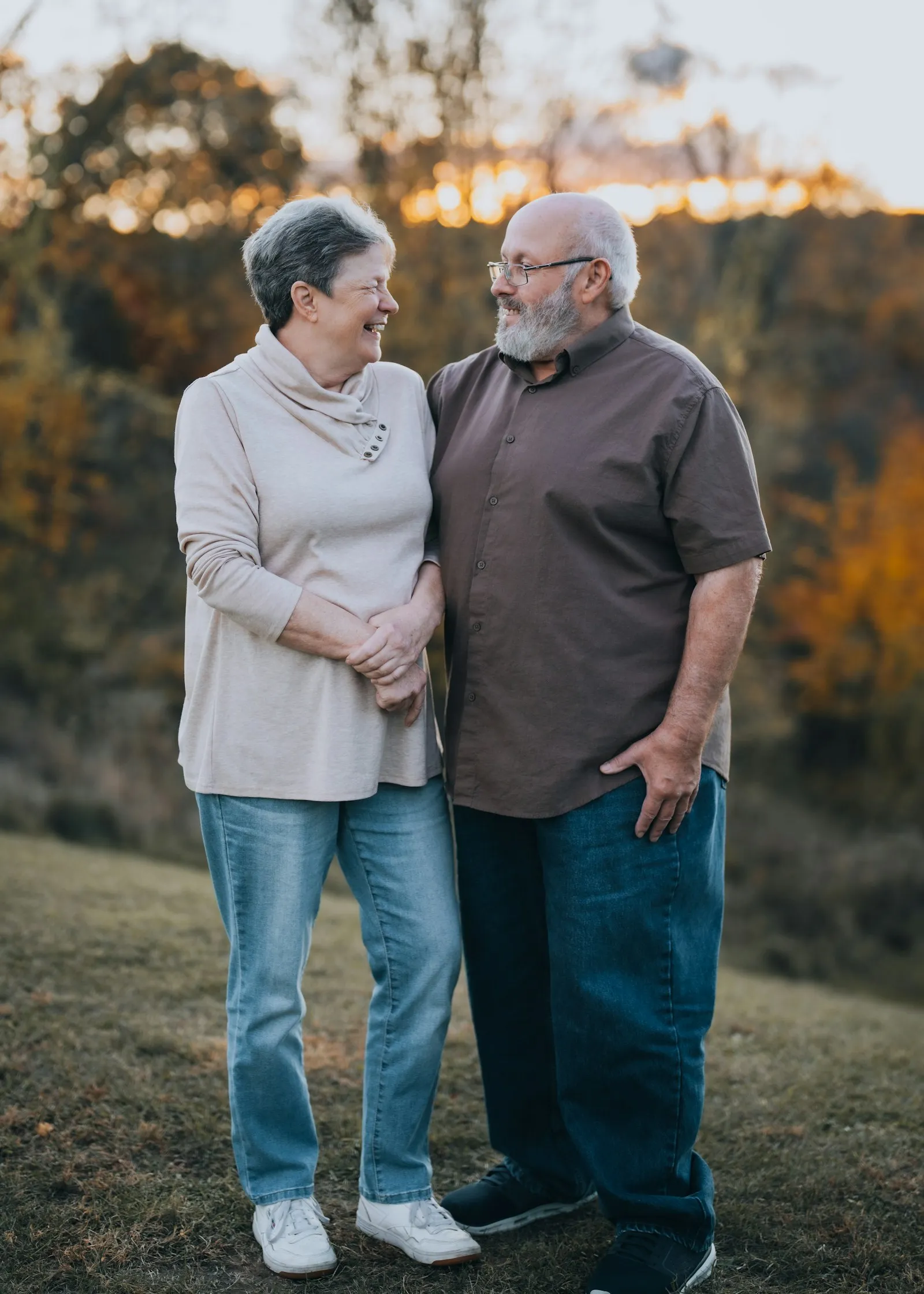 Casal de anfitriões sorrindo ao ar livre