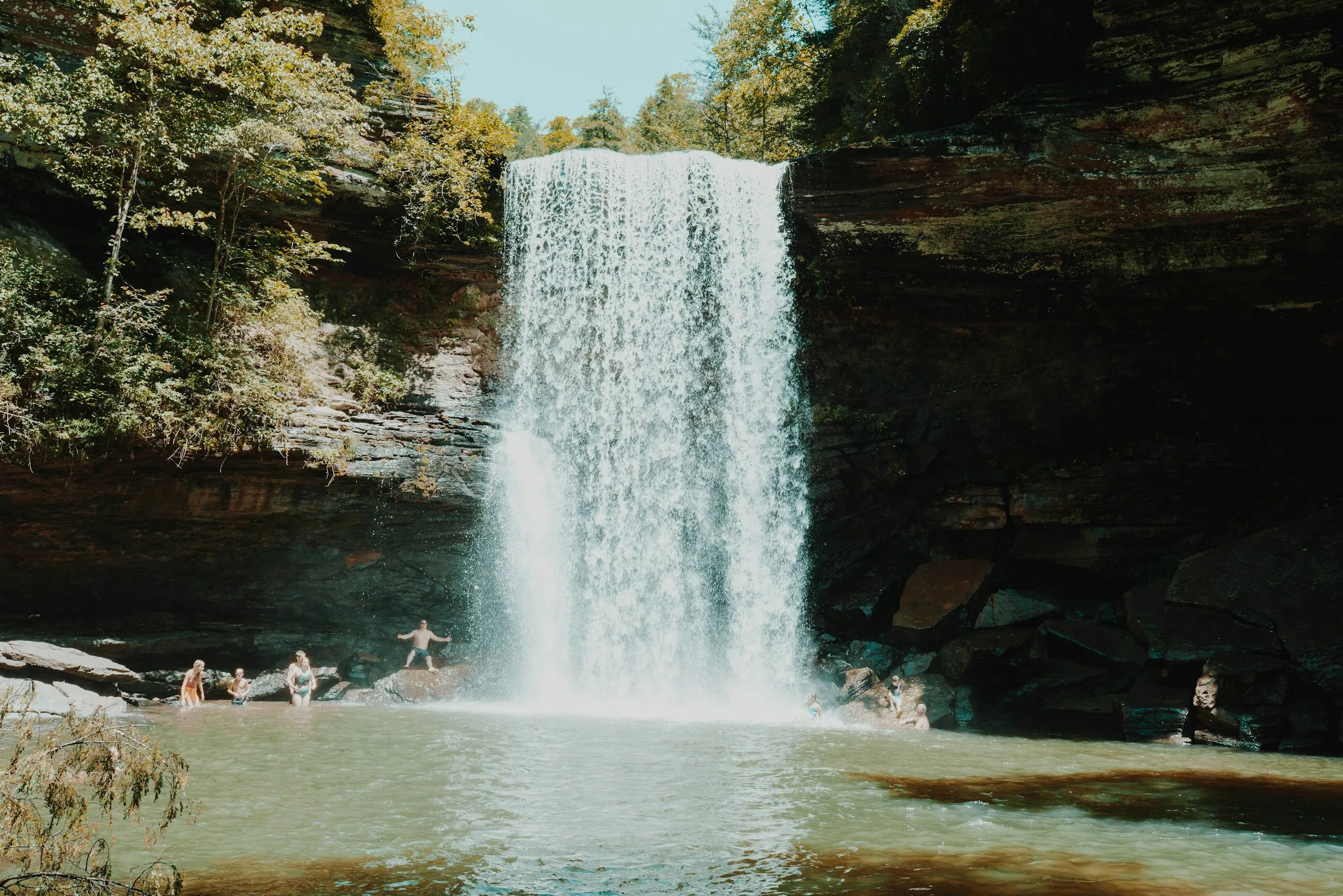 Cachoeira caindo em piscina natural cercada de pedras