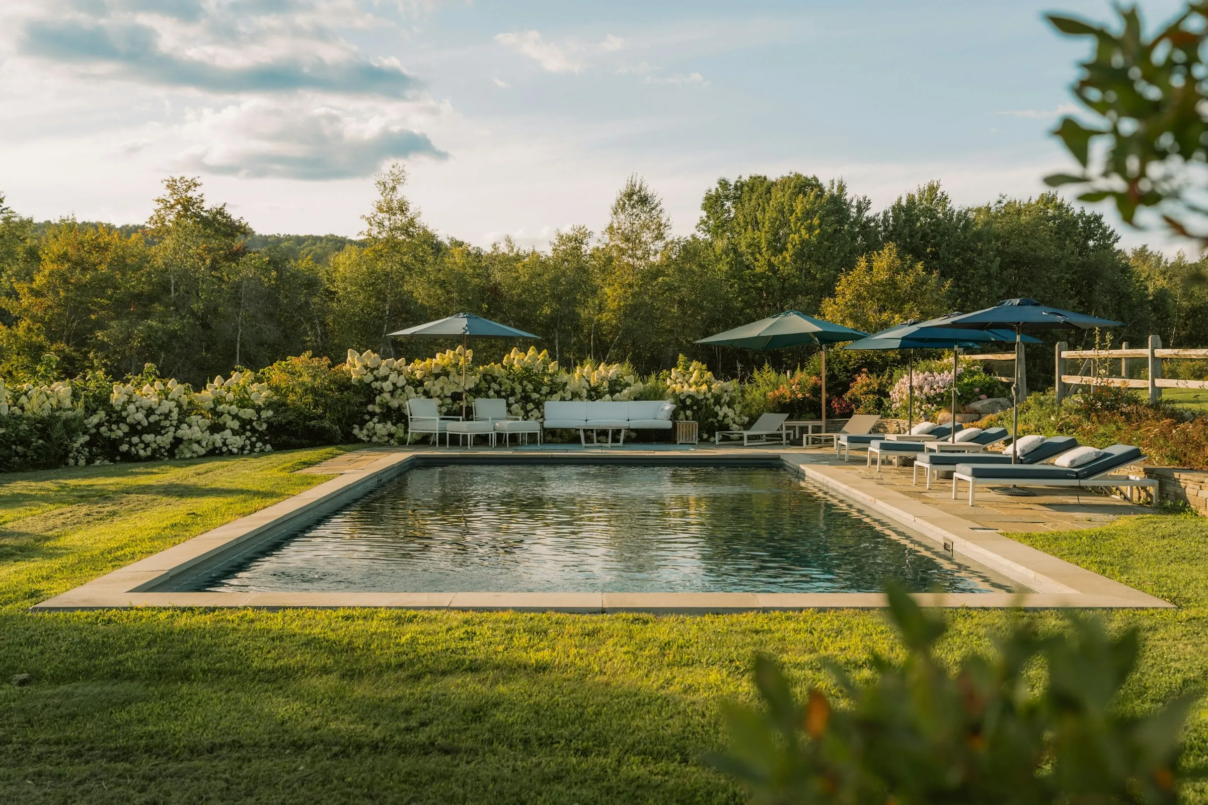 Piscina no jardim, com espreguiçadeiras e guarda-sóis