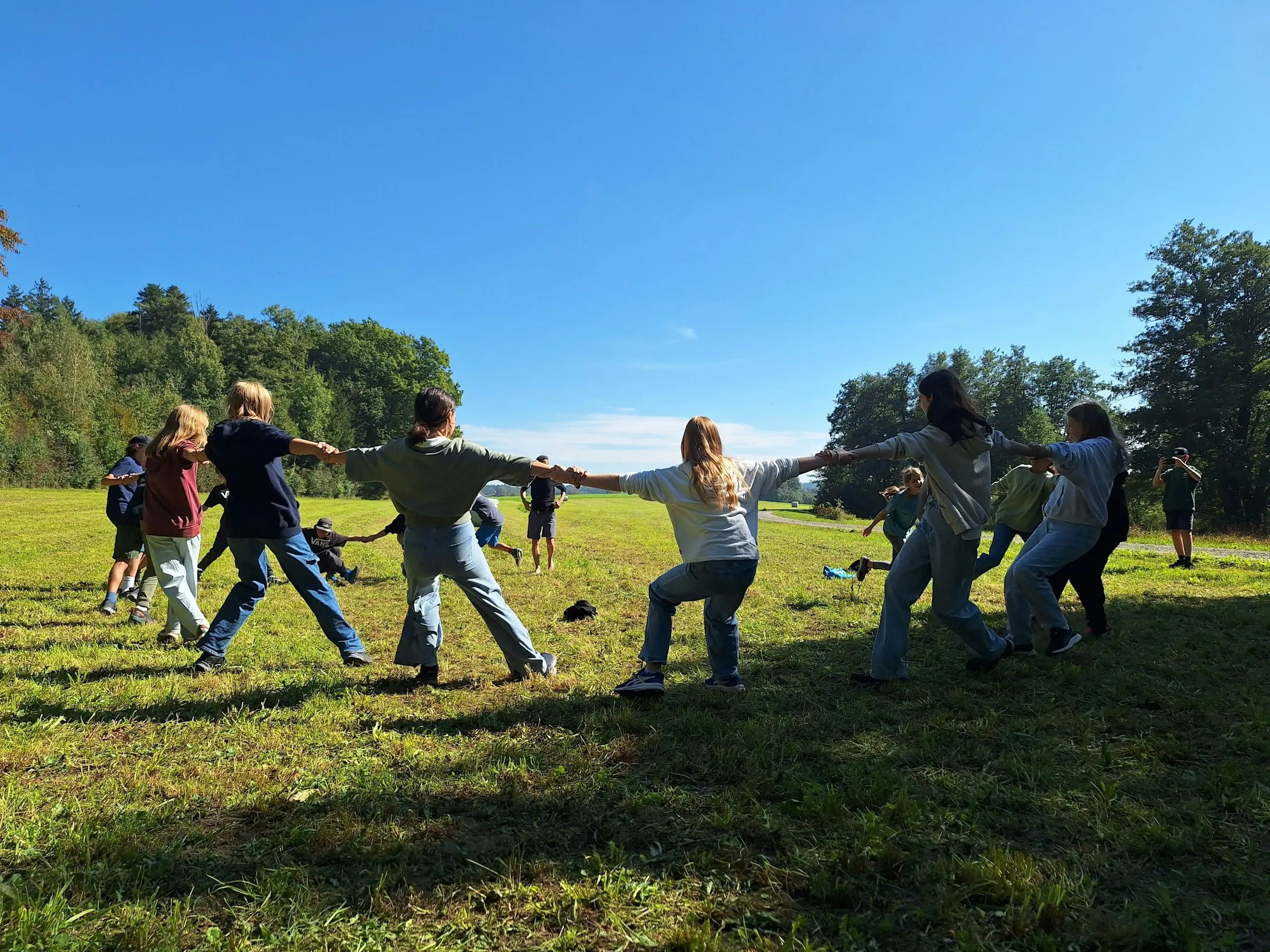 Crianças brincando de cabo de guerra no gramado